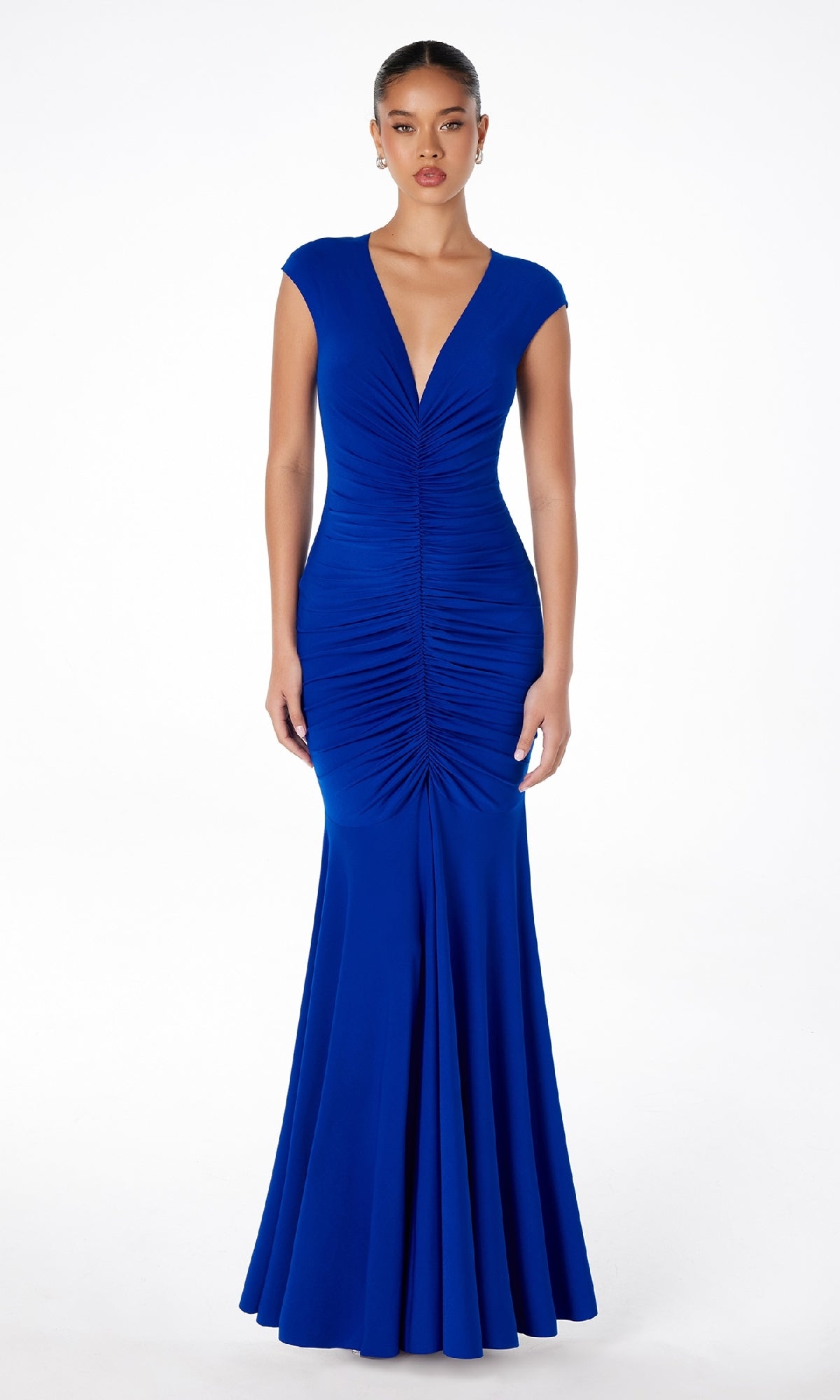 A woman faces forward in the Cap-Sleeve Long Ruched Prom Dress: Astee T2009, a royal blue, floor-length gown with a v-neckline, cap sleeves, and center ruched detailing.